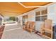Relaxing covered patio with neutral pavers, protective awning, and cozy seating arrangement for peaceful outdoor living at 1736 Watts Mill Way, The Villages, FL 32162