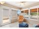 Bright sunroom featuring tile floors, natural light, and a cozy armchair with ottoman at 1736 Watts Mill Way, The Villages, FL 32162