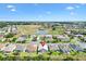 A neighborhood aerial view overlooking houses with green lawns near a scenic golf course and water at 17902 Se 115Th Cir, Summerfield, FL 34491
