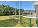 Backyard with green chain-link fence and a screened lanai, offering a secure outdoor space at 17902 Se 115Th Cir, Summerfield, FL 34491