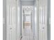 Hallway featuring linen closets, tile flooring, and a view into the main bathroom at 17902 Se 115Th Cir, Summerfield, FL 34491