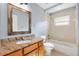 Traditional bathroom featuring a wood vanity with granite countertop and tiled tub and shower at 17902 Se 115Th Cir, Summerfield, FL 34491