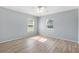 Bright bedroom featuring new light-colored wood floors and two windows for ample natural light at 17902 Se 115Th Cir, Summerfield, FL 34491