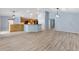 Spacious living room featuring wood-look floors, an open floor plan, and modern lighting at 17902 Se 115Th Cir, Summerfield, FL 34491