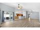 Bright living room featuring wood-look floors, an open floor plan, ceiling fan, and access to a sunroom at 17902 Se 115Th Cir, Summerfield, FL 34491