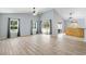 Large living room with vaulted ceilings, wood-look tile floors, and a kitchen bar at 17902 Se 115Th Cir, Summerfield, FL 34491