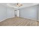 Main bedroom featuring wood-look floors, vaulted ceiling, and an arched doorway to the main bathroom at 17902 Se 115Th Cir, Summerfield, FL 34491