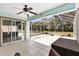 Enclosed patio with tile flooring, ceiling fan, and screened windows, perfect for outdoor relaxation at 17902 Se 115Th Cir, Summerfield, FL 34491