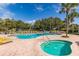 A community pool with clear blue water, lounge seating, umbrellas, and a relaxing atmosphere at 17902 Se 115Th Cir, Summerfield, FL 34491