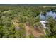 Scenic aerial view of the property showcasing proximity to a lake surrounded by lush greenery at 19938 Burkitt Rd, Dunnellon, FL 34432