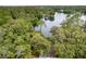 Stunning aerial view of a lakeside property surrounded by lush, mature trees and tranquil waters at 19938 Burkitt Rd, Dunnellon, FL 34432
