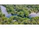 Stunning aerial view of riverfront properties surrounded by dense forest and serene waters at 19938 Burkitt Rd, Dunnellon, FL 34432