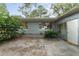 Exterior shot of backyard featuring large windows, greenery, and potential outdoor space at 19938 Burkitt Rd, Dunnellon, FL 34432