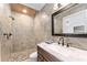 Bathroom with stone tiled shower and rustic vanity at 19938 Burkitt Rd, Dunnellon, FL 34432