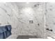 Stunning shower showcasing marbled walls, sleek fixtures, and modern dark mosaic tile flooring at 19938 Burkitt Rd, Dunnellon, FL 34432