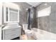 Bathroom with gray tiled walls, modern vanity and shower/tub combination at 19938 Burkitt Rd, Dunnellon, FL 34432