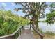 Private wooden dock overlooking serene lake waters, surrounded by lush foliage and hanging moss at 19938 Burkitt Rd, Dunnellon, FL 34432