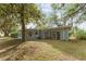 Exterior shot of home surrounded by mature trees, and a view of the side and back of the home at 19938 Burkitt Rd, Dunnellon, FL 34432