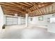 Spacious garage with exposed wooden beams, bright lighting, and ample room for multiple vehicles at 19938 Burkitt Rd, Dunnellon, FL 34432