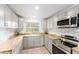 Contemporary kitchen with gray cabinets, wooden countertops, white backsplash, and stainless steel appliances at 19938 Burkitt Rd, Dunnellon, FL 34432