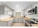 Modern kitchen featuring gray cabinets, butcher block countertops, and stainless steel appliances at 19938 Burkitt Rd, Dunnellon, FL 34432