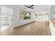 Bright and airy living room featuring hardwood floors, white walls, and large windows with backyard views at 19938 Burkitt Rd, Dunnellon, FL 34432