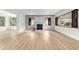 Bright living room featuring hardwood floors, a brick fireplace and large windows with natural light at 19938 Burkitt Rd, Dunnellon, FL 34432