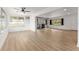 Bright living room with hardwood floors, white walls, and a fireplace and large windows at 19938 Burkitt Rd, Dunnellon, FL 34432