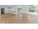 Open-concept living area with light wood flooring and lots of natural light from large windows at 19938 Burkitt Rd, Dunnellon, FL 34432