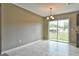 Bright dining area featuring tile floors, sliding glass doors to the backyard and a modern chandelier at 21911 Sw Nautilus Blvd, Dunnellon, FL 34431