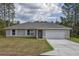 Charming single-story home featuring a two car garage, neutral color palette, and well-maintained lawn at 21911 Sw Nautilus Blvd, Dunnellon, FL 34431