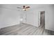 Light-filled bedroom with wood-look floors, fan, closet, and ensuite bath with gray tiled shower at 23964 Nw Falcon Ave, Dunnellon, FL 34431