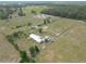 Aerial view of acreage with horse facilities, home, and multiple out buildings at 258 Nw 122Nd Ave, Oxford, FL 34484