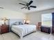 Bedroom with a ceiling fan, wooden furniture, and a large window offering views of greenery at 258 Nw 122Nd Ave, Oxford, FL 34484
