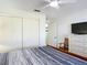Bedroom featuring a ceiling fan, closet, and door with an adjacent bureau and television at 258 Nw 122Nd Ave, Oxford, FL 34484