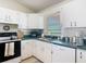 Bright kitchen featuring white cabinets, green countertops, and modern appliances at 258 Nw 122Nd Ave, Oxford, FL 34484