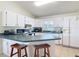 Bright kitchen featuring white cabinets, green countertops, and a breakfast bar at 258 Nw 122Nd Ave, Oxford, FL 34484