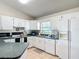 Bright kitchen featuring white cabinets, green countertops, and modern appliances at 258 Nw 122Nd Ave, Oxford, FL 34484