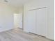 Bedroom with light wood-look floors, white walls, and folding closet doors at 2627 Sw 154Th Place Rd, Ocala, FL 34473