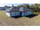 View of the rear exterior featuring a covered porch, sliding glass door, and lawn at 2627 Sw 154Th Place Rd, Ocala, FL 34473