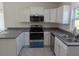Well-equipped kitchen features stainless steel appliances, granite counters, and bright white cabinets at 2803 Sw 147Th Ct, Ocala, FL 34481