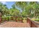 A wood deck offers a tranquil view of the lush backyard, full of plants and trees, and is covered in brown leaves at 426 Sw 13Th St, Ocala, FL 34471