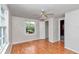 The bedroom has hardwood floors, a ceiling fan, a window overlooking a yard, and access to the closet and hallway at 426 Sw 13Th St, Ocala, FL 34471