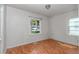 The bedroom has hardwood floors, neutral walls, a window overlooking a yard, and an overhead light at 426 Sw 13Th St, Ocala, FL 34471