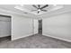 Spacious bedroom with decorative tray ceiling, ceiling fan, and neutral color palette at 4314 Se 131St Ln, Belleview, FL 34420