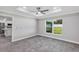 Bright bedroom featuring gray tile flooring, a window, and open access to the kitchen at 4314 Se 131St Ln, Belleview, FL 34420