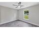 Cozy bedroom with neutral walls, gray tiled floors, and a view to the yard at 4314 Se 131St Ln, Belleview, FL 34420