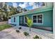 Close up of the entry to a light blue home with decorative rock and green foliage around the walkway at 4314 Se 131St Ln, Belleview, FL 34420