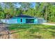 Charming single-story home featuring a blue exterior, a well-manicured lawn, and a fenced yard at 4314 Se 131St Ln, Belleview, FL 34420