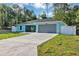 Charming single-story home boasts a manicured lawn, gray roof, an attached two car garage, and a light blue exterior at 4314 Se 131St Ln, Belleview, FL 34420